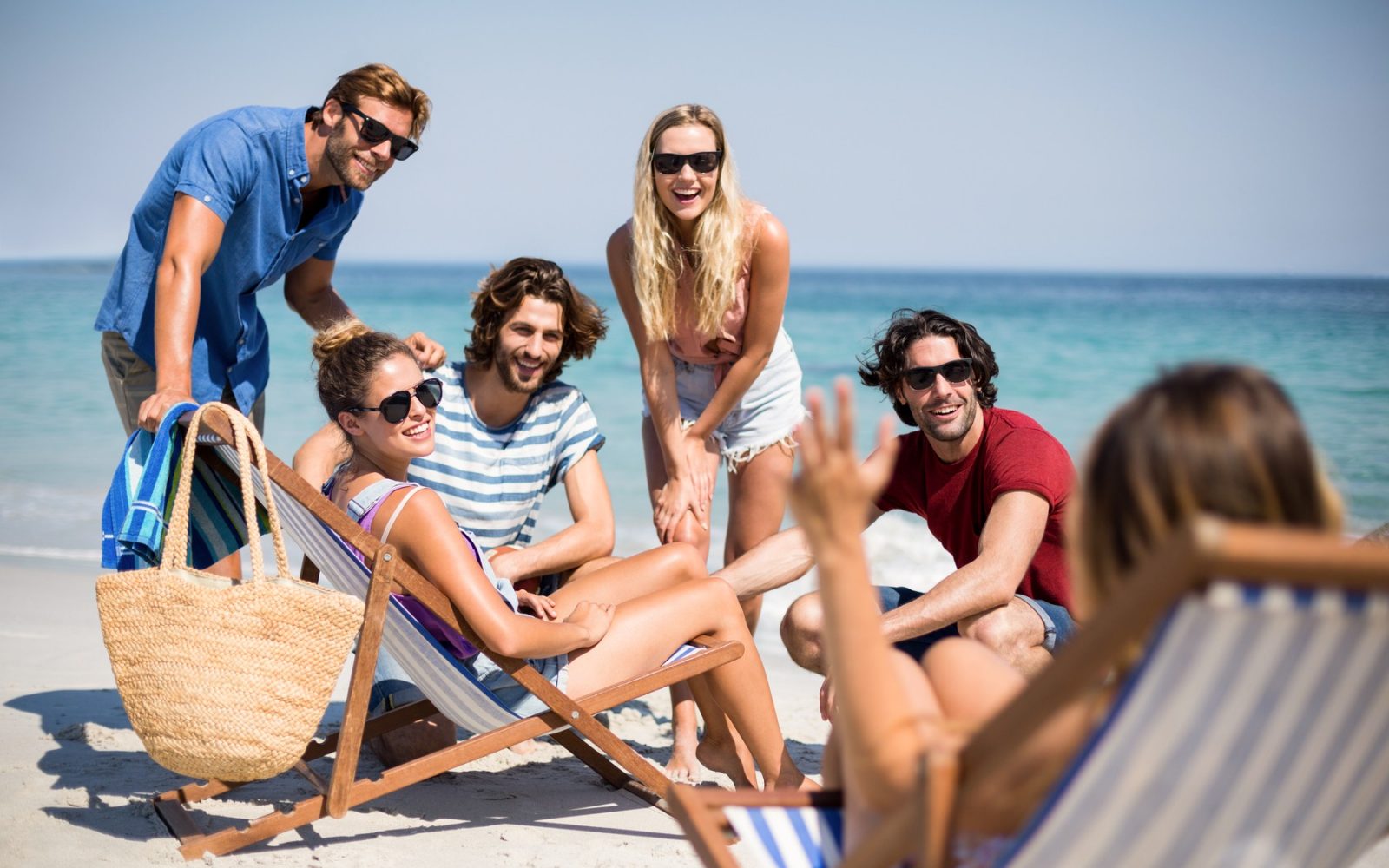 skupina prijatevljev na plaži klepeta