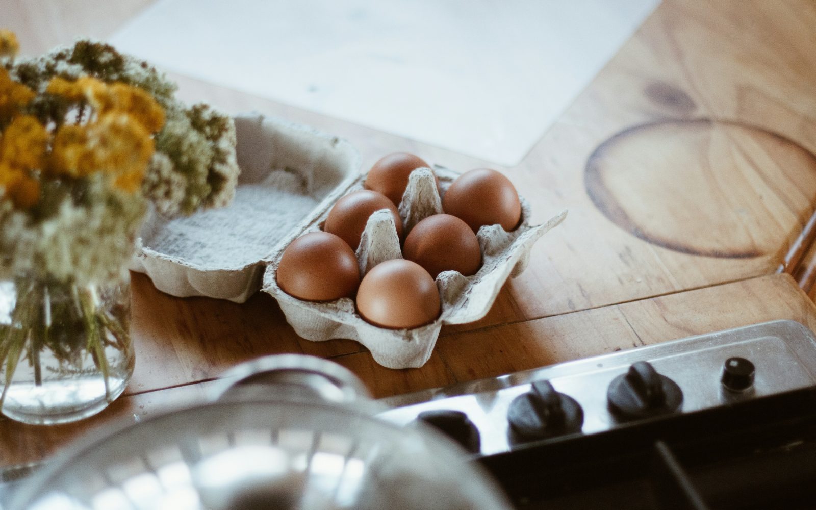 Koliko jajc je zdravo pojesti? Šest jajc je v kartonu, na pultu ob štedilniku