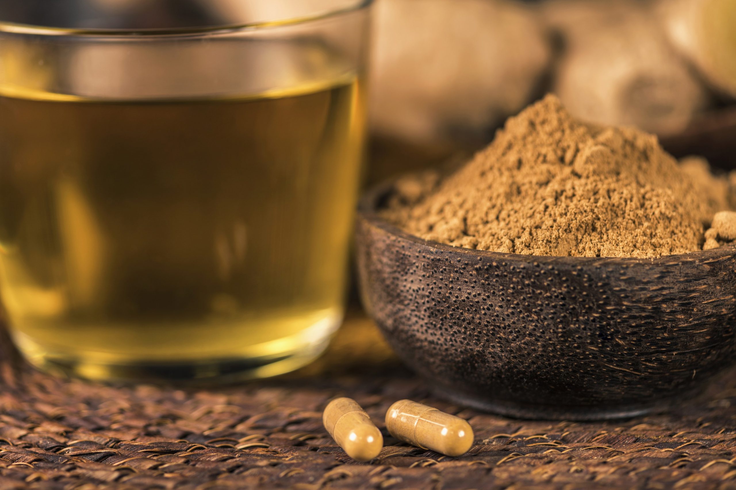 Na mizi so ingverjeve kapsule, mlet ingver, svež ingver in ingverjev čaj - naravno zdravilo proti slabosti in morski bolezni.