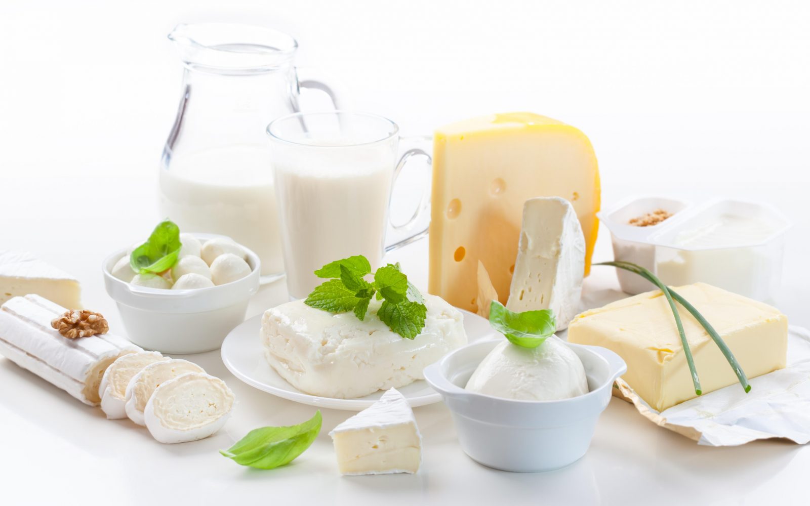 Na sliki so različni mlečni izdelki - mleko, jogurt, sir, skupta, maslo, ki so pomemben del uravnotežene prehrane, bogat vir kalcija, beljakovin in vitaminov, a imajo lahko nekatere škodljive učinke.