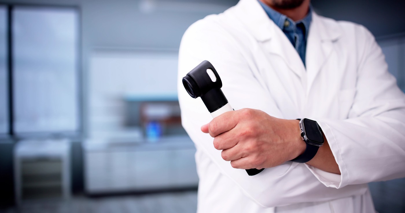 Dermatolog s dermatoskopom opozarja na nevarnosti sončnih opeklin in kožnega raka