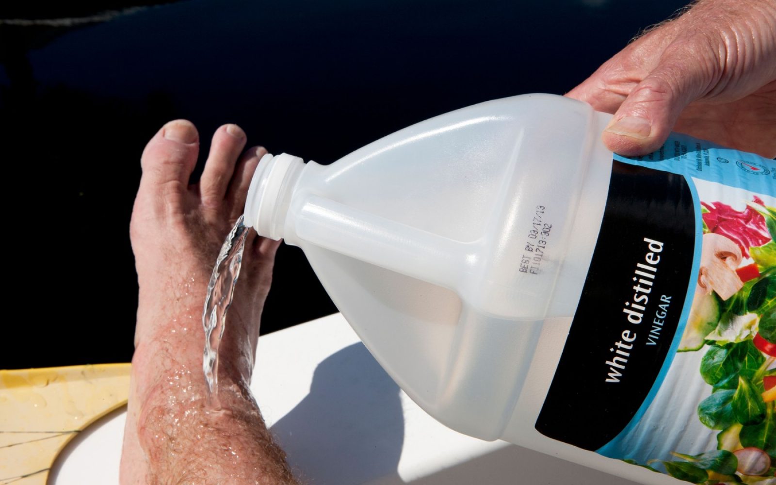 Stopalo, ki je utrpelo ožig meduze, polivajo s kisom kot prvo pomoč.