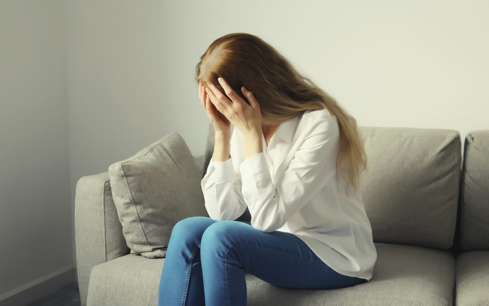 Žalostna ženska, prestrašena in zmedena, joka zaradi vpliva mentalne bolezni na njeno počutje in odnose.