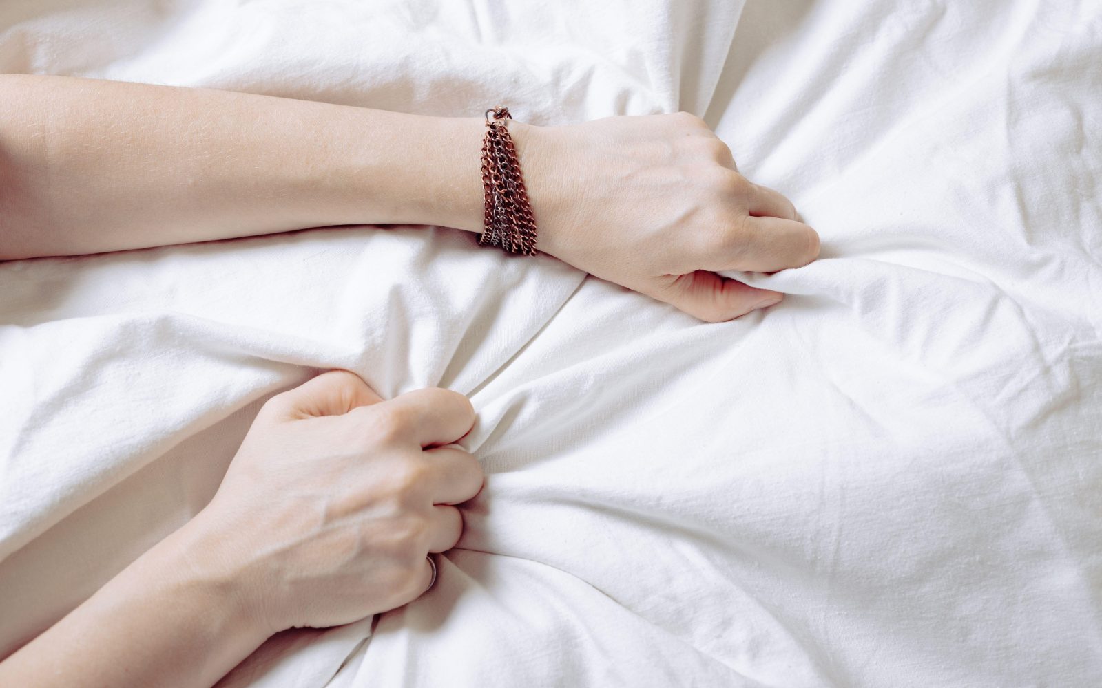 Ženska grabi rjuhe; simbolika orgazma in užitka