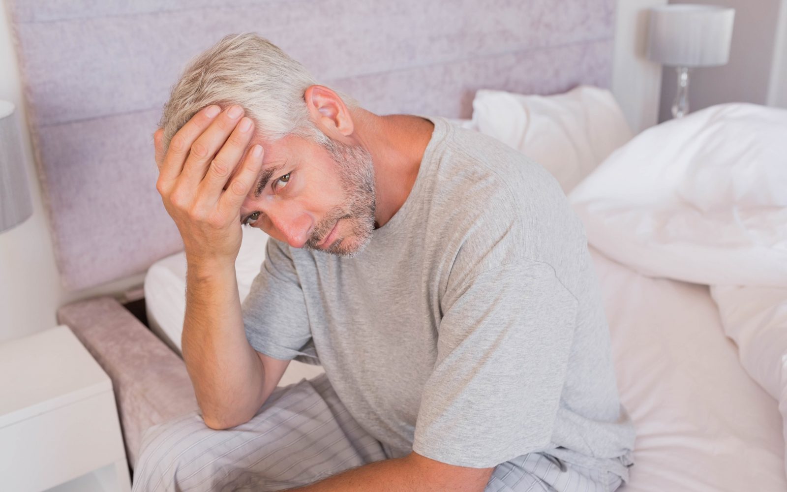 Moški se drži za glavo, je utrujen, utrujenost je eden od tako imenovanih b simptomov