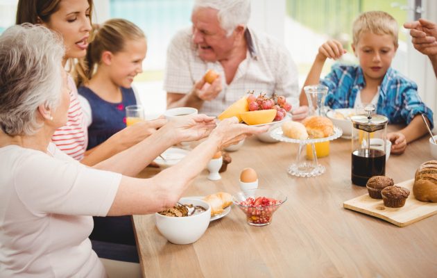 Družina, starša, stara starša in dva otroka, skupaj zajtrkujejo in se družijo ob obroku - pomemben dejavnik za zdravje in dobro počutje