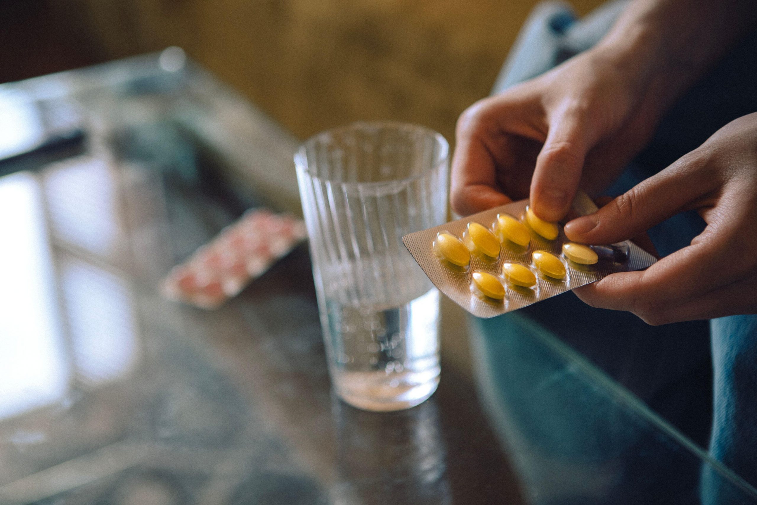 Ženska, ki zavita v odeje jemlje zdravilo proti bolečinam brez recepta - varna uporaba zahteva, da preberemo navodila za uporabo in se jih dosledno držimo