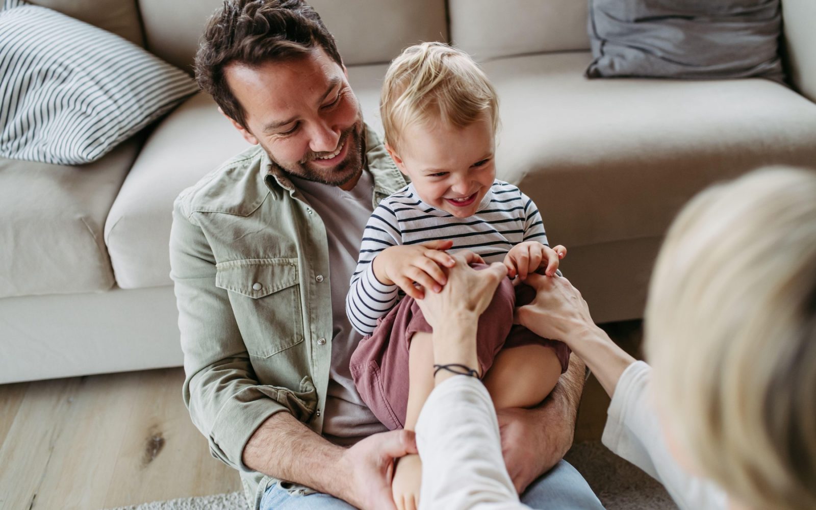 očka s sinom v naročju se igra z zdravnico homeopatinjo