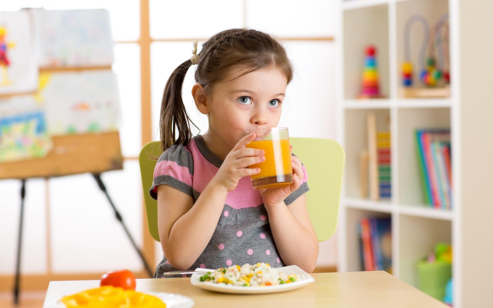 Deklica s kozarcem soka in zdravim zajtrkom