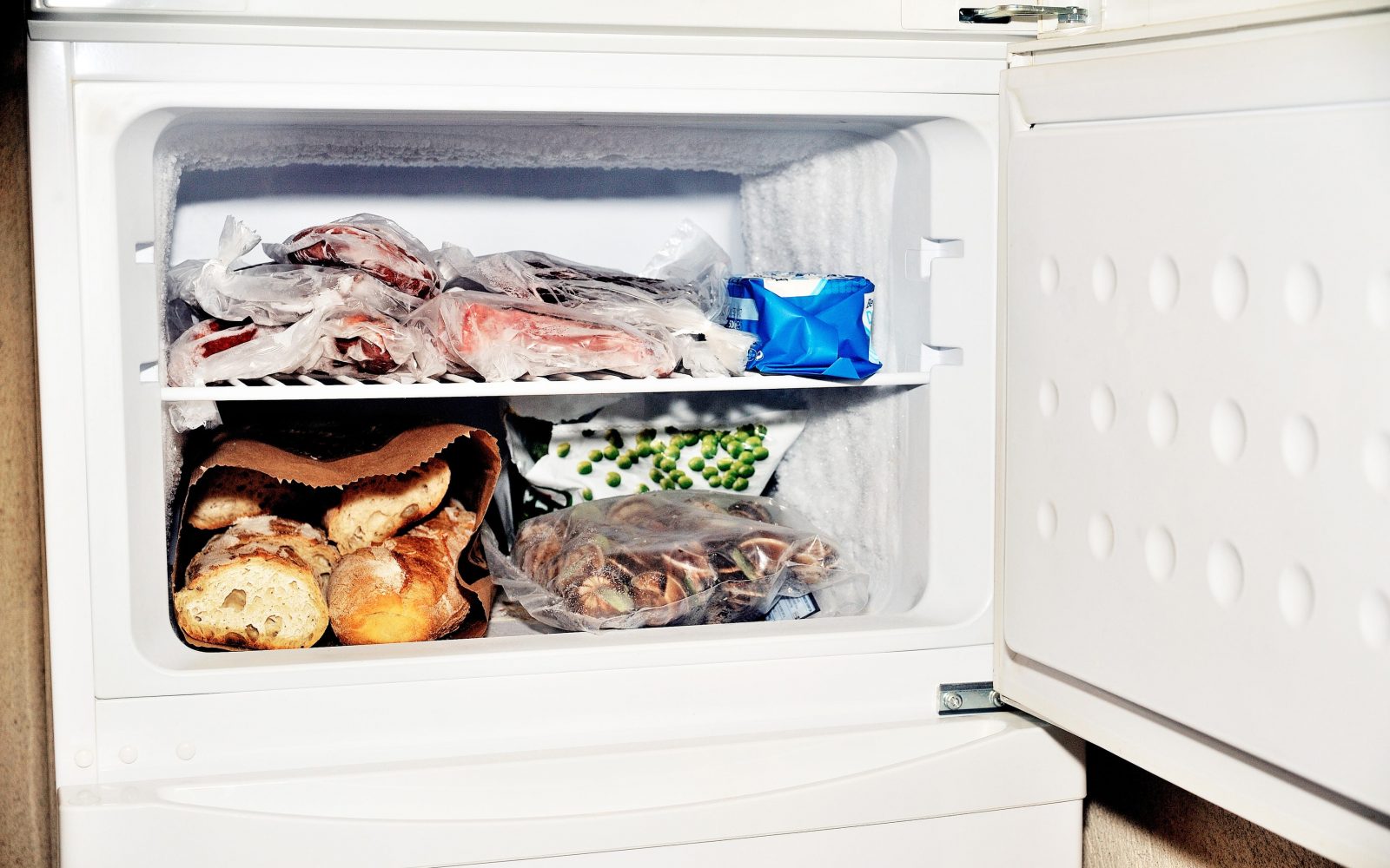 Predal v zamrzovalniku, kjer so različna živila, tudi kruh