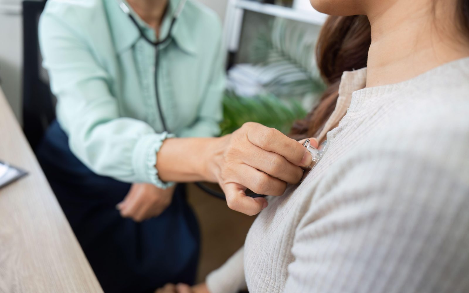 Zdravnica s stetoskopom posluša srce pri ženski bolnici