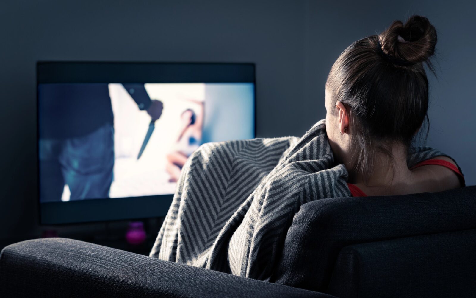 Dekle gleda grozljivko na zaslonu