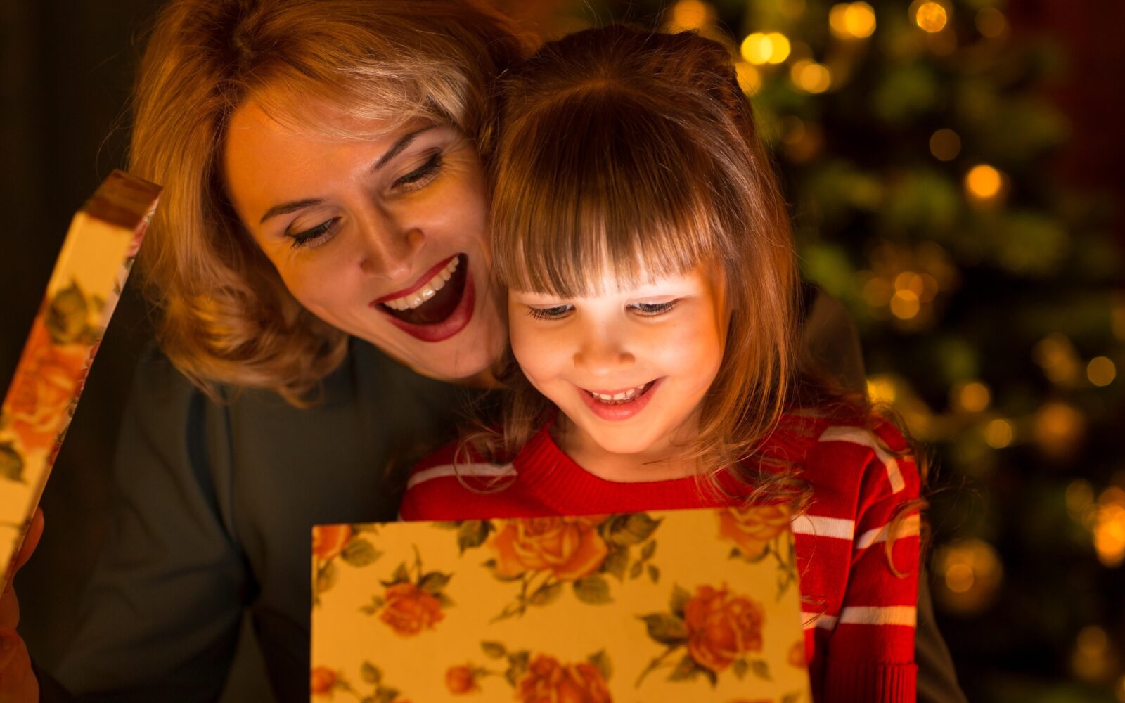 Mati in hči, hči odpira praznično darilo