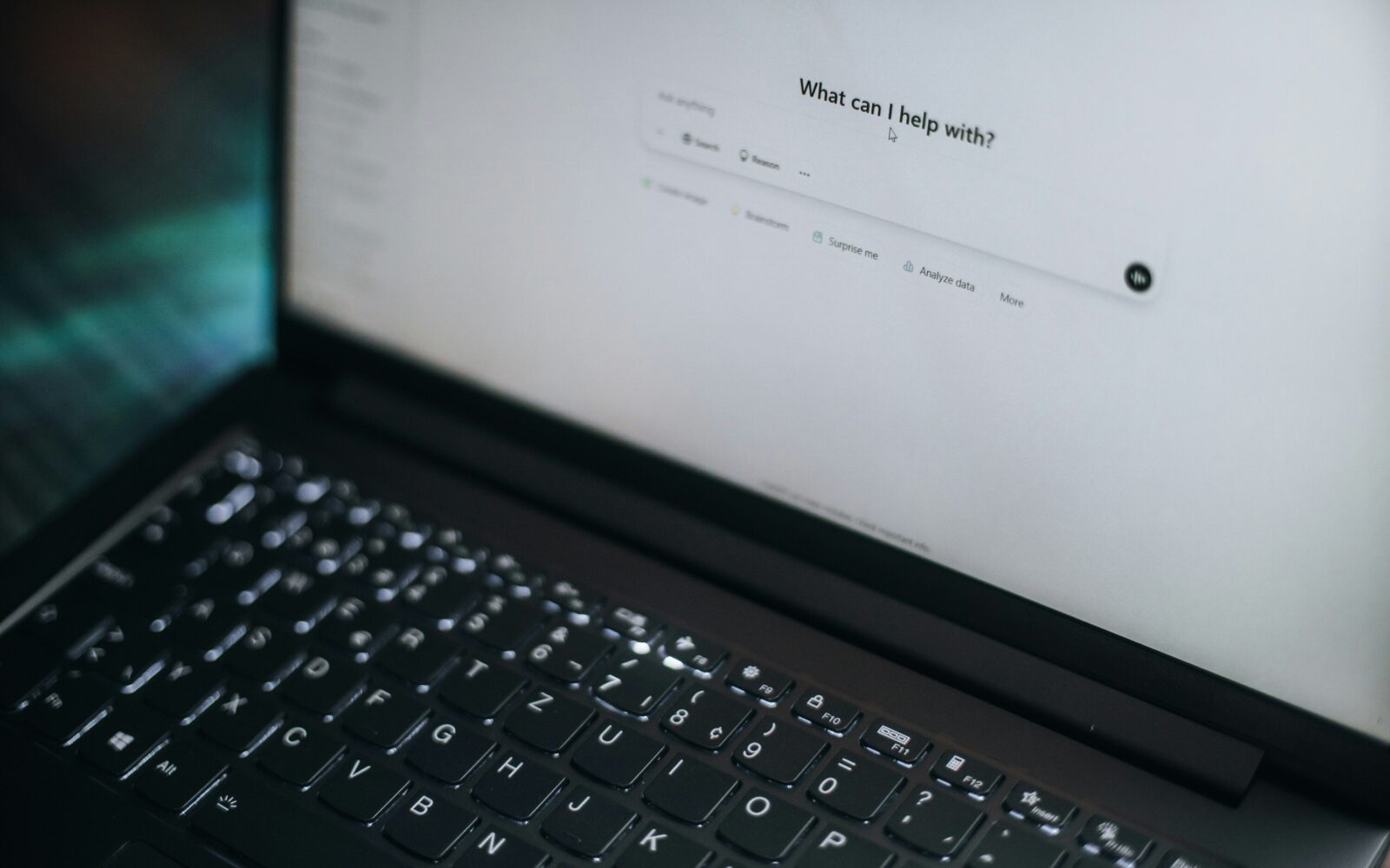 Na prenosnem računalniku je odprta platforma chatGPT, ki sprašuje uporabnika, kako mu lahko pomaga