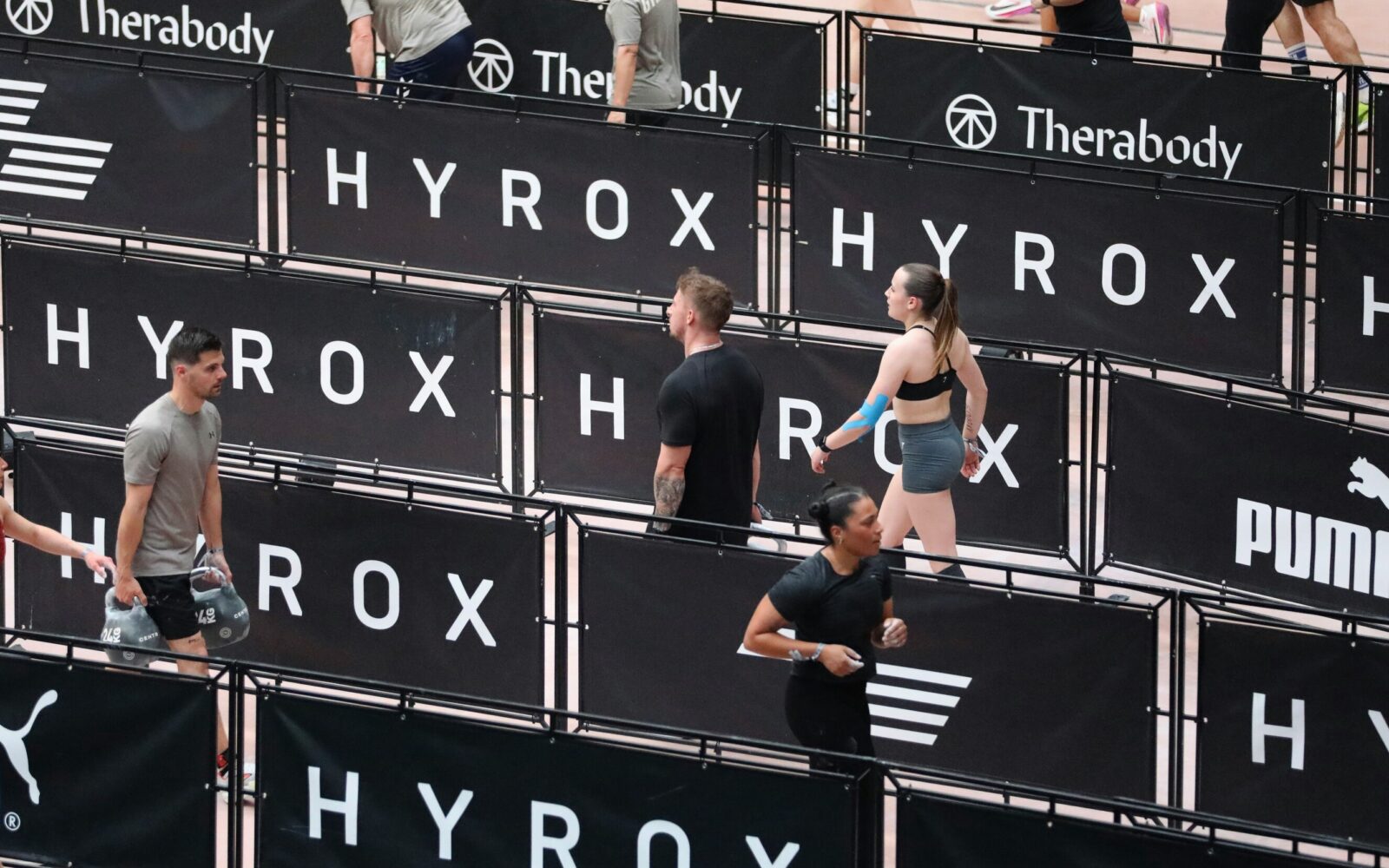 Hyrox tekmovanje - farmers carry, disciplina pri kateri hodiš z utežmi.