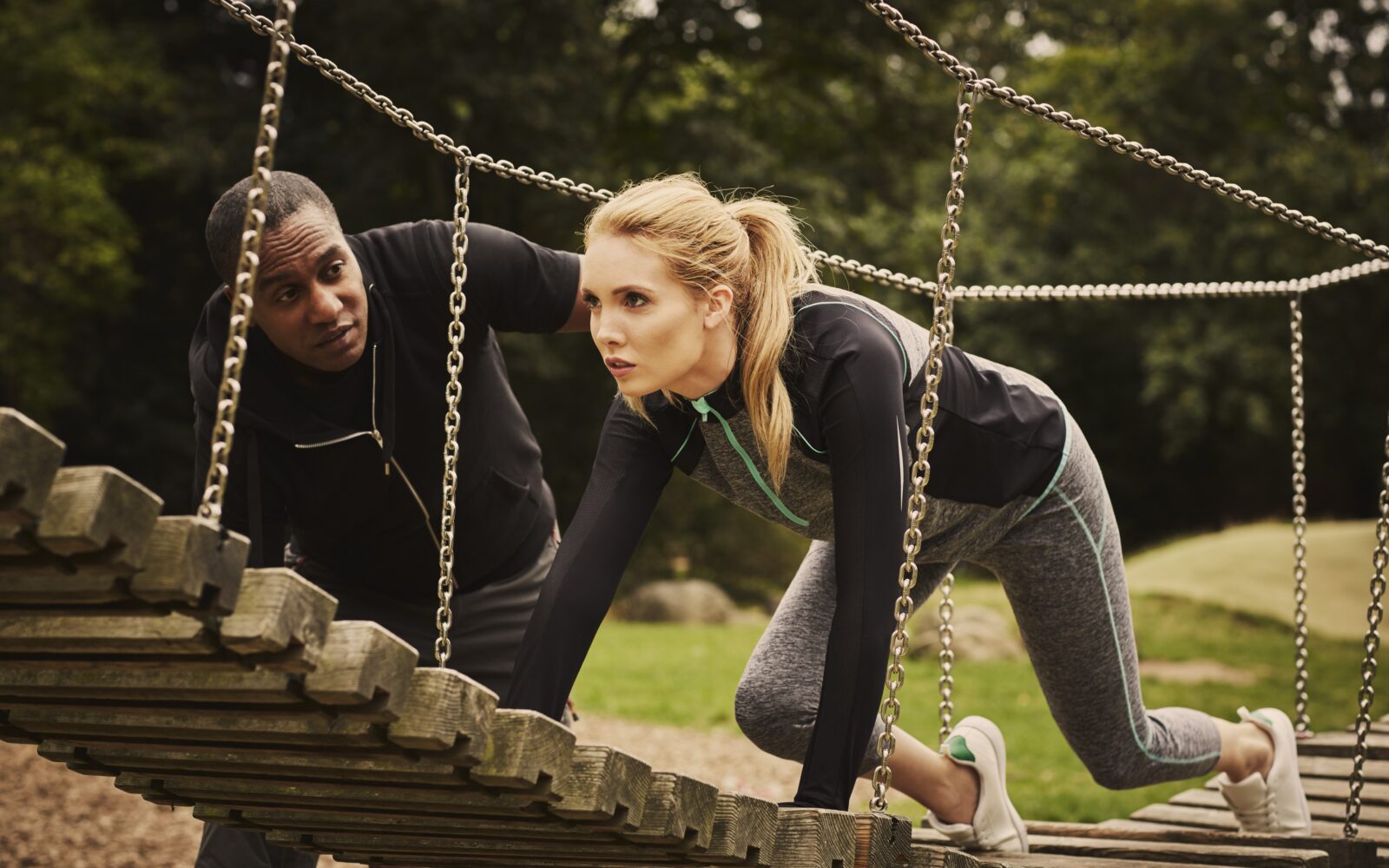 Mlada ženska izvaja kvadrobiko skupaj z osebnim trenerjem - zanimiv in drugačen način vadbe.