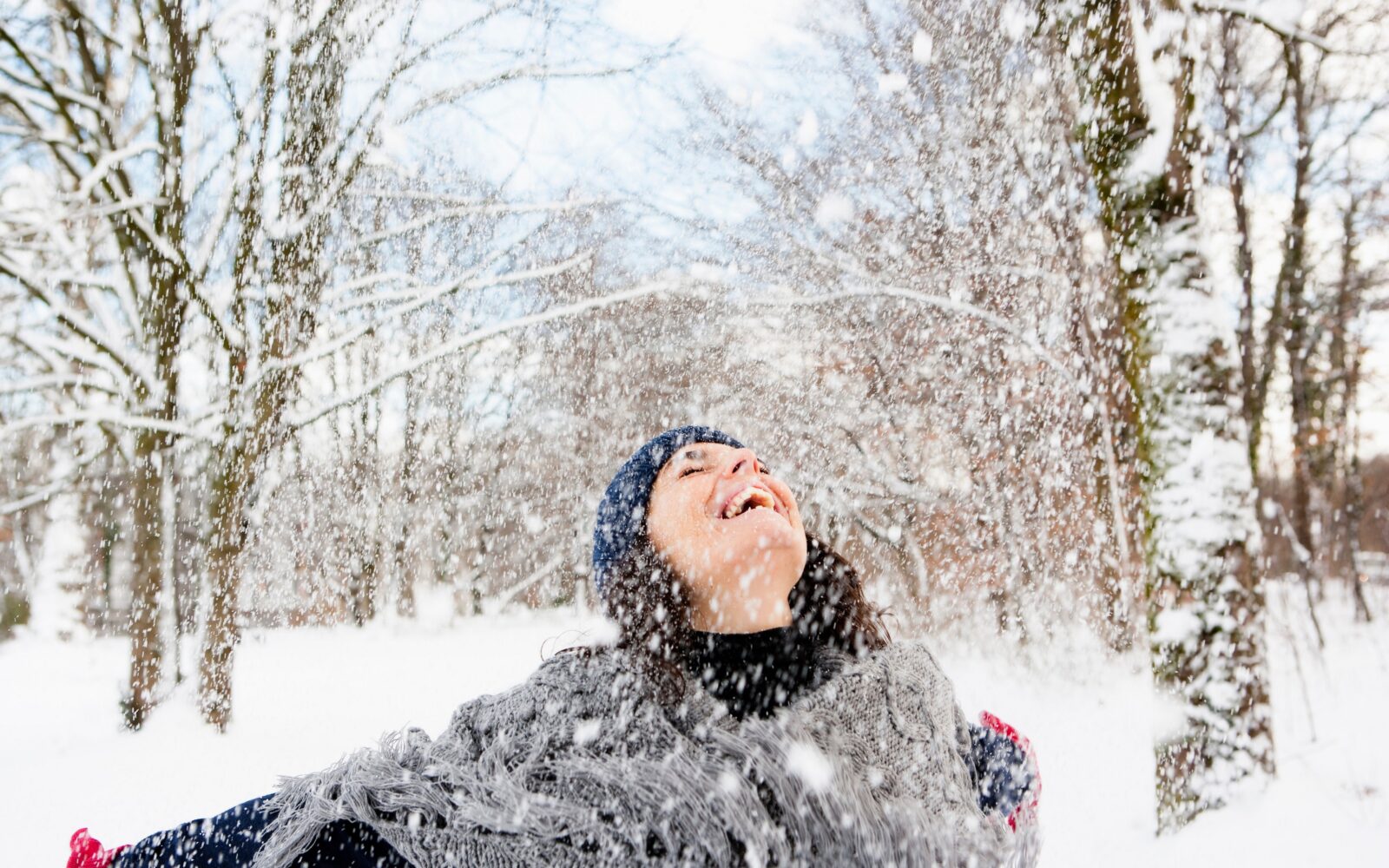 Ženska uživa v snegu in hladnem vremenu - kljub negativim vplivom mrazu na naše zdravje