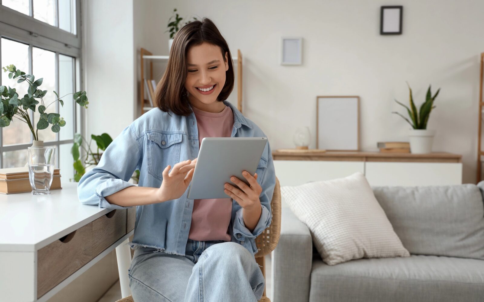 Deklica ima v rokah tablični računalnik in se smeji