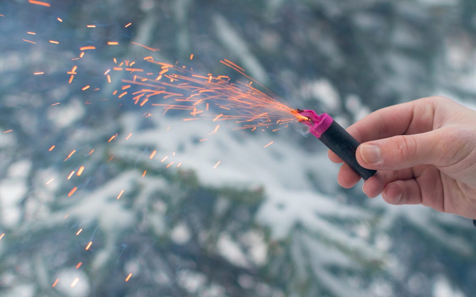 Moški drži petardo v roki - glasna in nevarna zabava s številnimi negativnimi posledicami za okolje in zdravje ljudi in živali