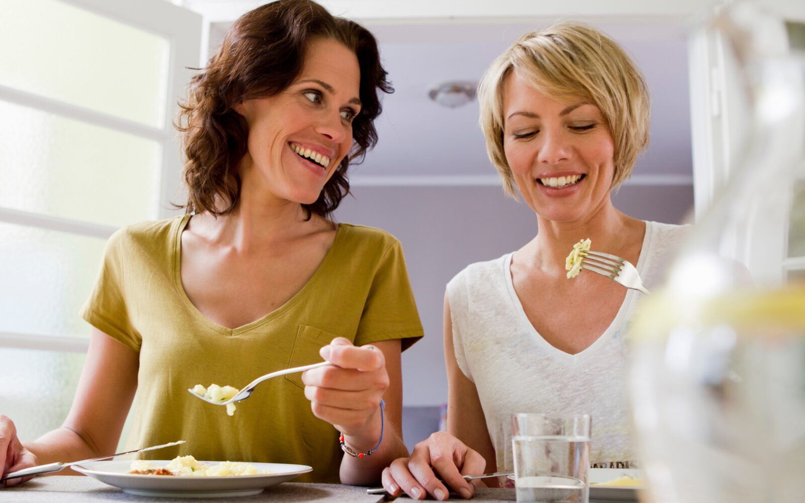 Nasmejani ženski skupaj jesta kosilo