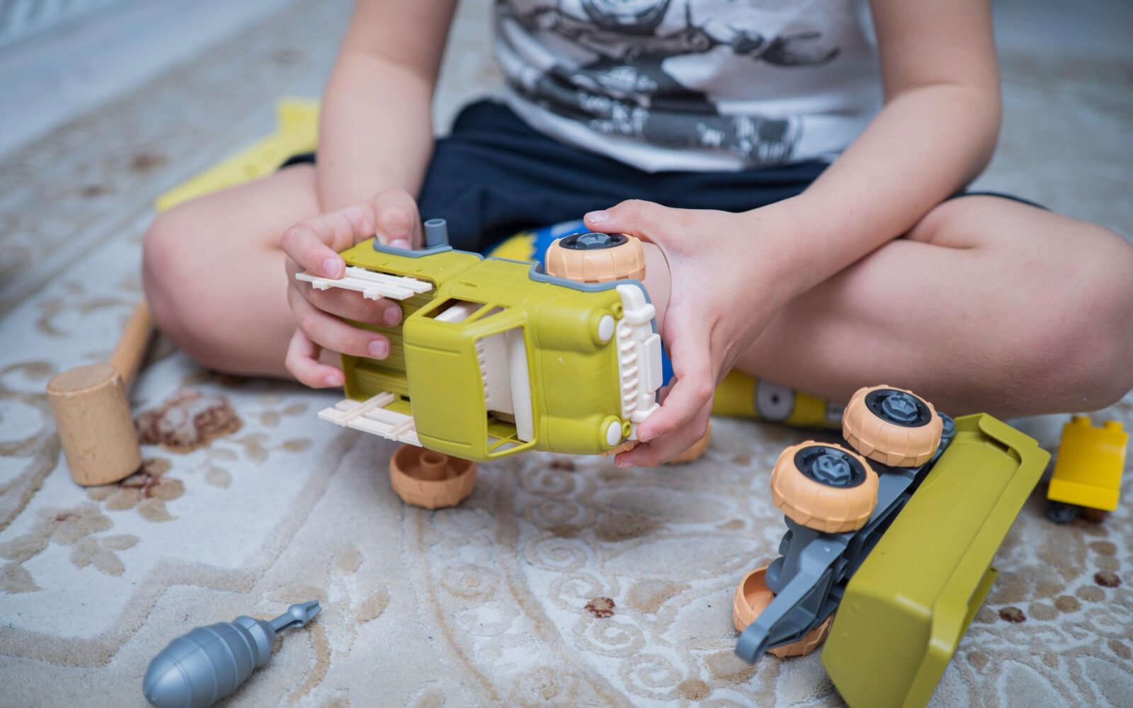 Fantek z avtistično motnjo se igra z avtomobilom