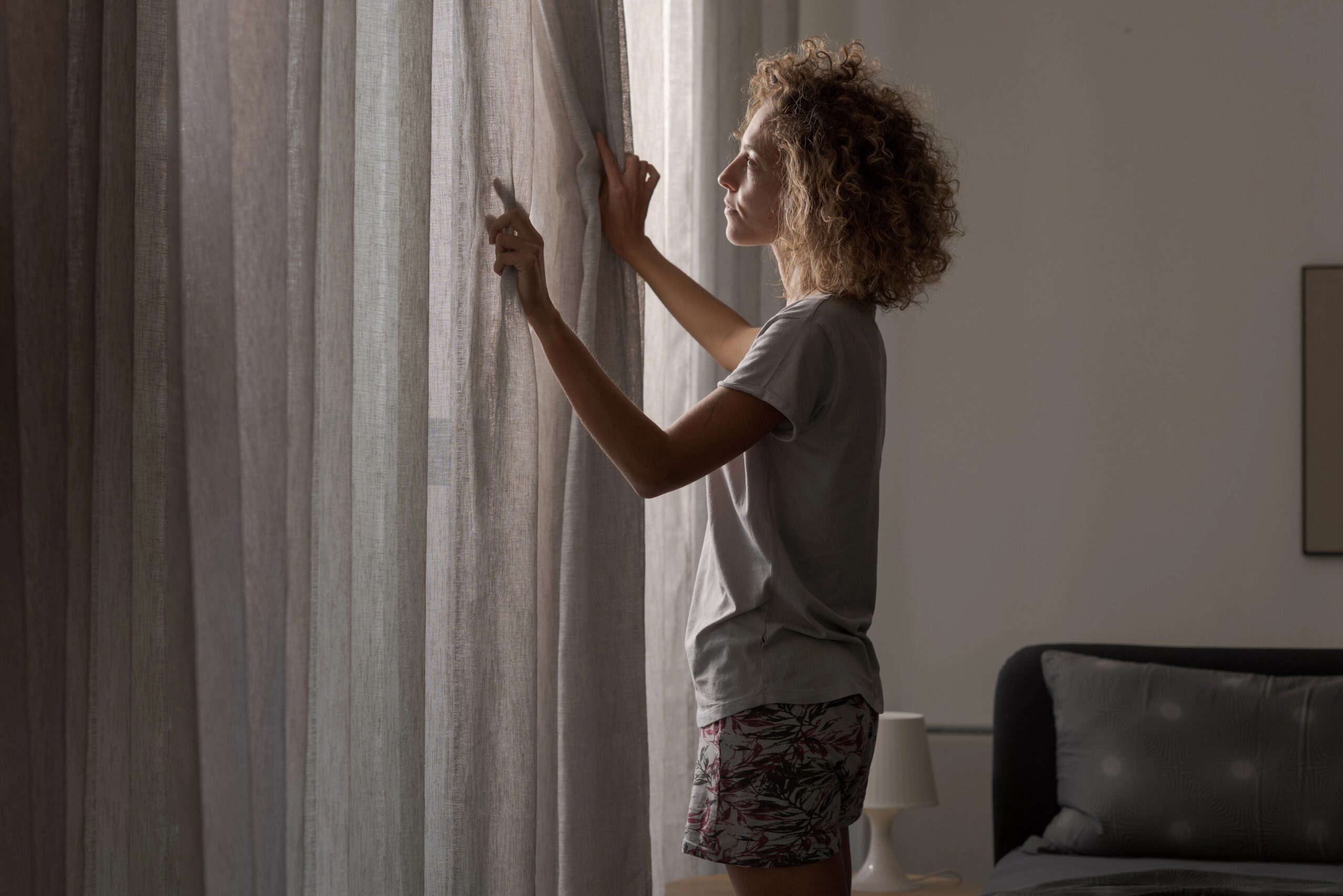 Ženska pred spanjem zastre zavese za kakovosten in nemoten spanec