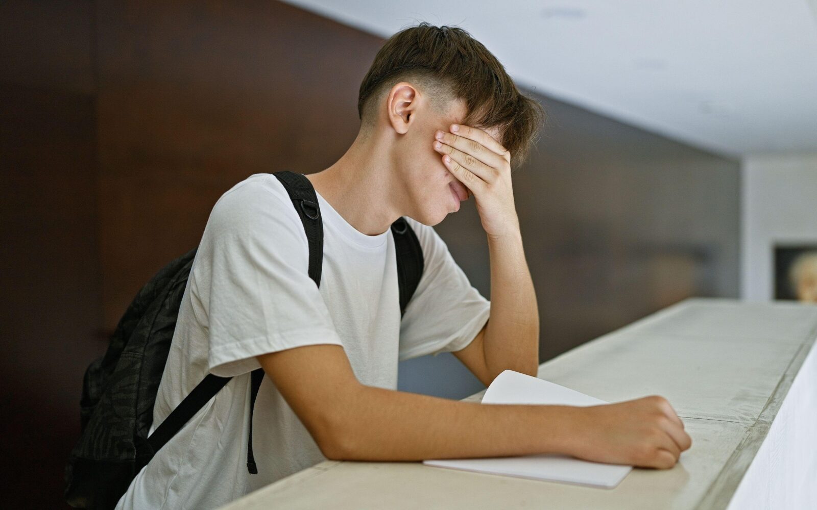 mladostnik se drži za glavo, je v stresu ali ga boli glava