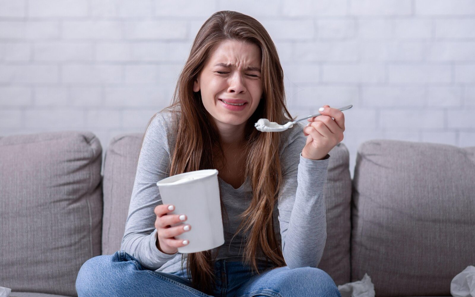 Žalostna ženska joka in se tolaži tako, da je sladoled