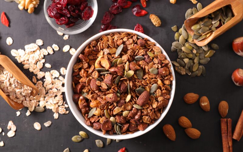 Skleda ovseen kaše z dodatkom oreščkov, mandljev, semen, brusnic, cimeta in orehov za zdrav in uravnotežen zajtrk