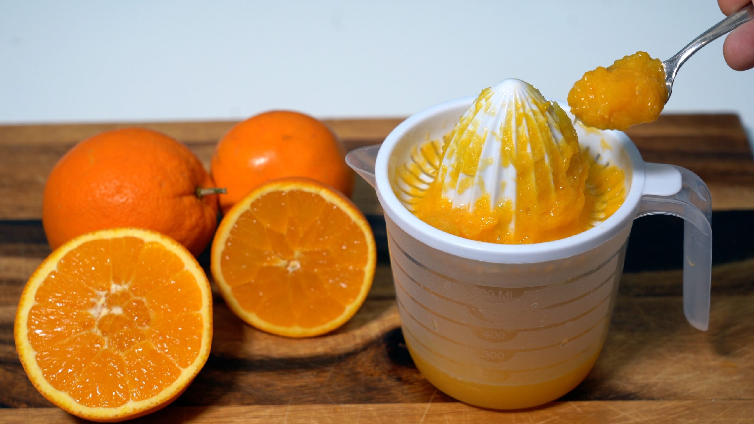 Na polovico narezane pomaranče in iztisnjen sok 