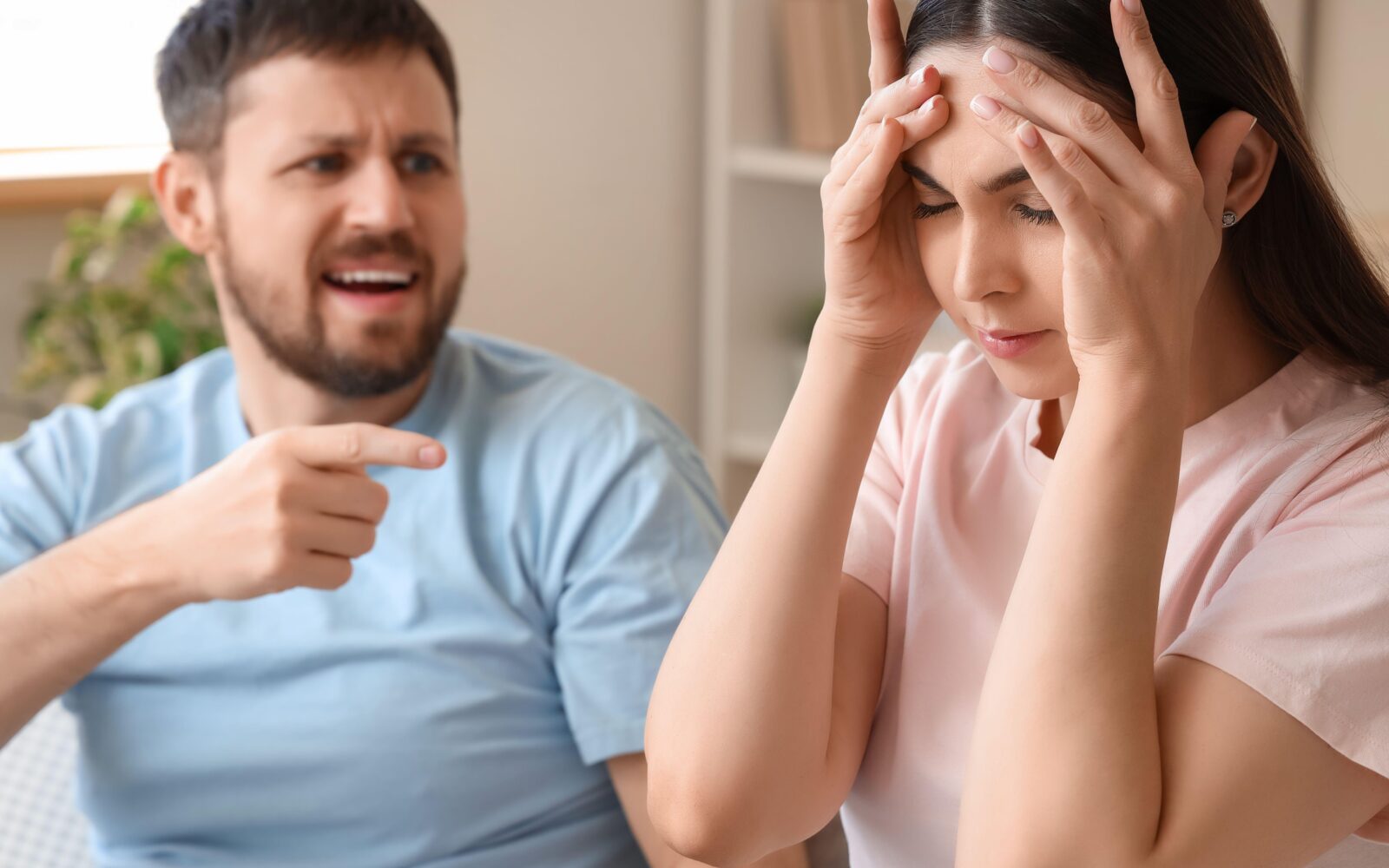 Moški in ženska se prepirata, moški s prstom kaže na žensko