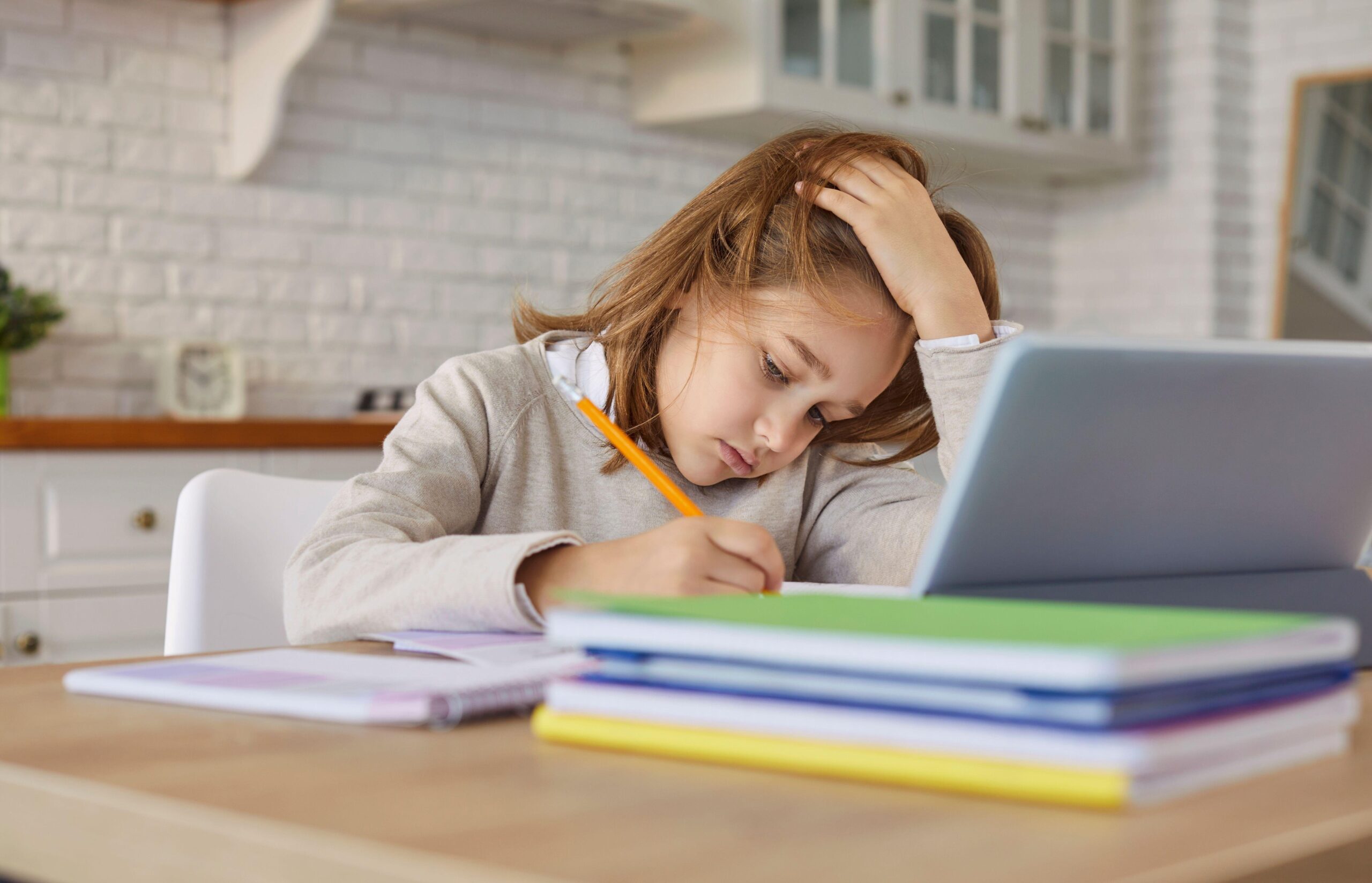 Utrujen otrok dela domačo nalogo in se slabo drži, kar ima lahko resne posledice za hrbetnico.