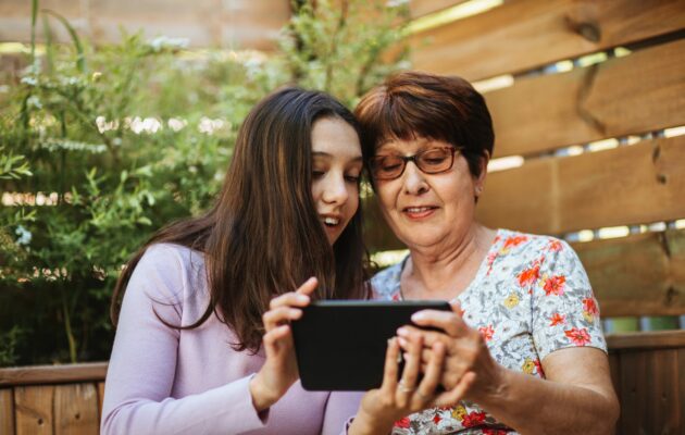 vnukinja in babica ob učenju novih veščin na telefonu