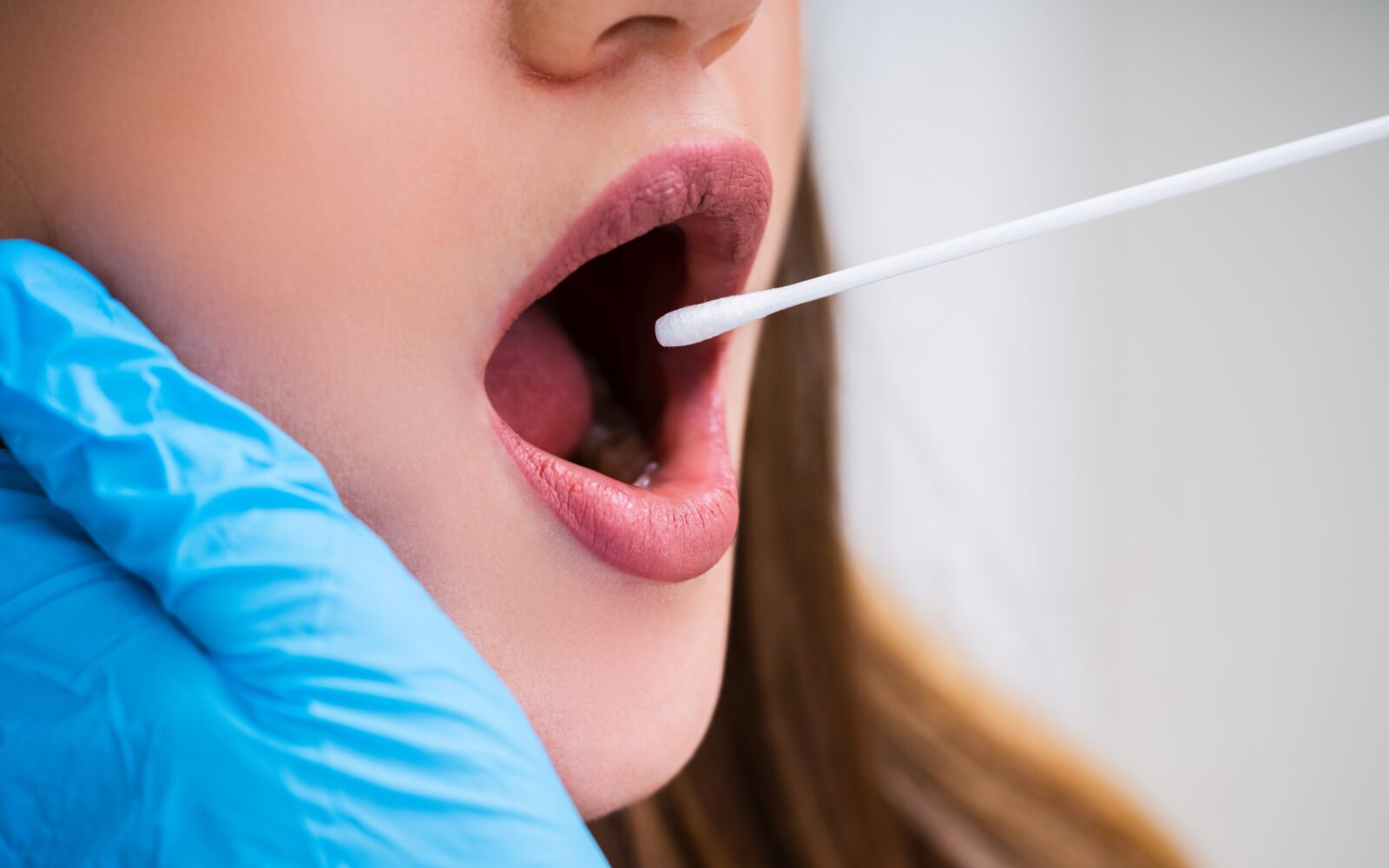 Ženski odvzemajo vzorec DNK iz ust