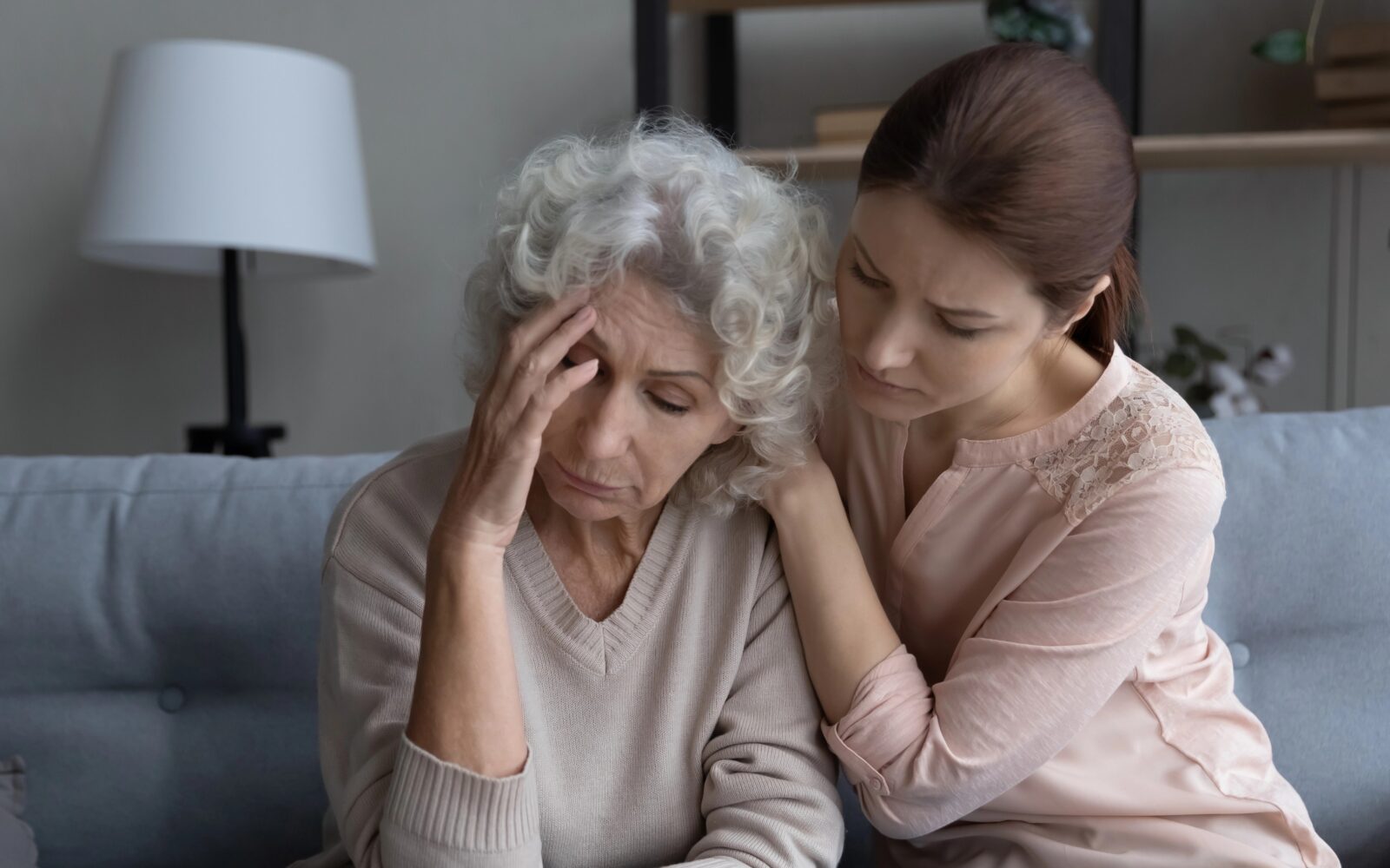 Ženska objema in tolaži starejšo osebo, ki je nemirna in v stresu