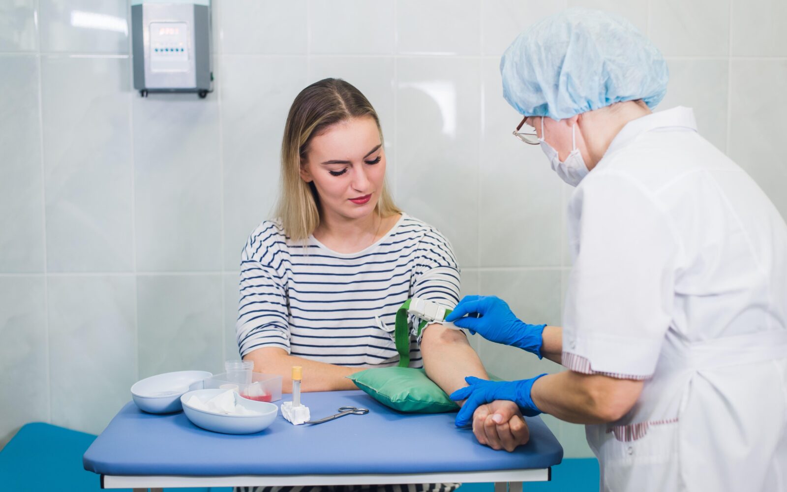 Ženska v laboratoriju daje vzorec krvi za krvne preiskave