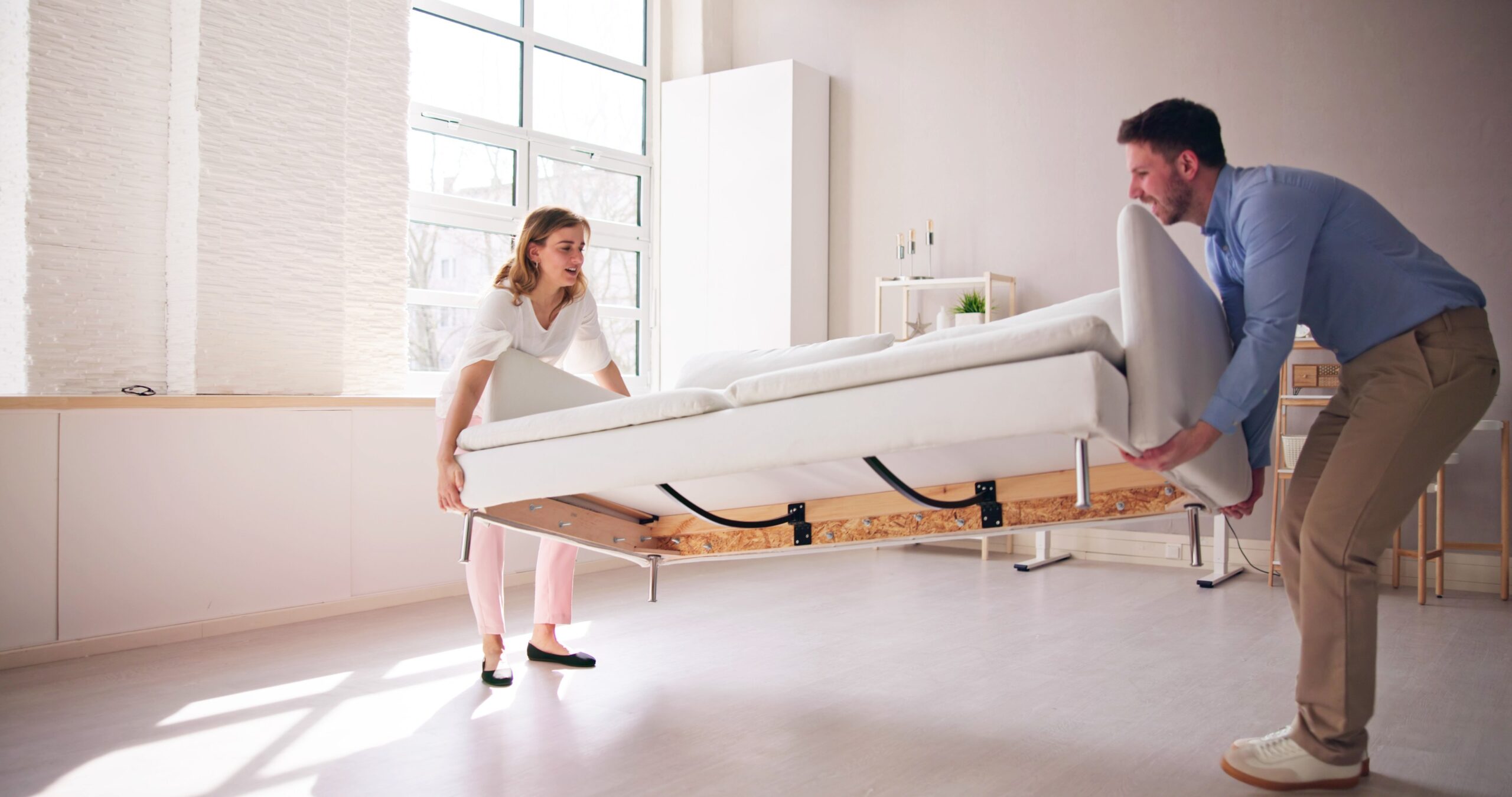 Par dviguje težak kavč, kar lahko povzroči hernijo diska