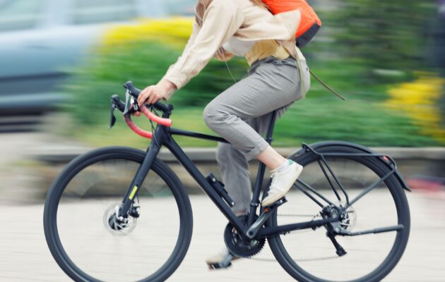 oseba v vsakdanjih oblačilih se vozi na kolesu