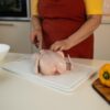 Priprava surovega piščanca na kuhinjski deski – pravilno ravnanje s surovim mesom