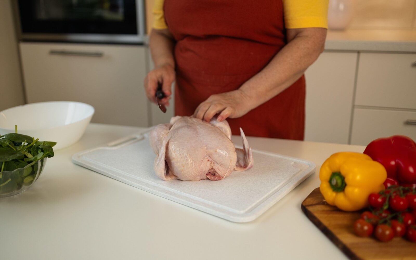 Priprava surovega piščanca na kuhinjski deski – pravilno ravnanje s surovim mesom