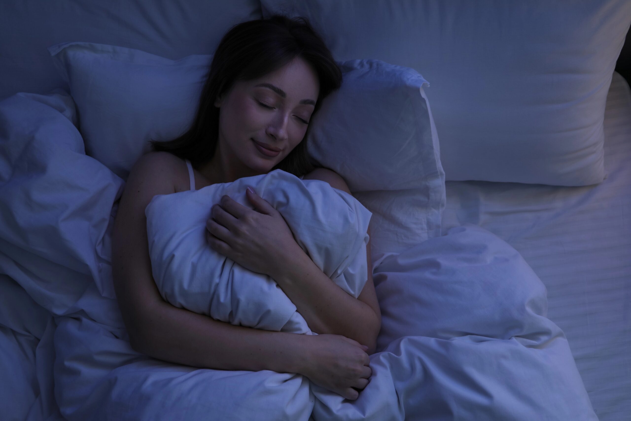 Lepa ženska, ki spi v postelji doma.