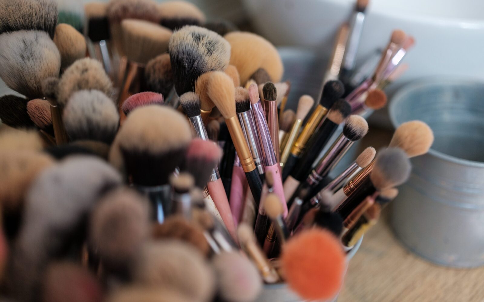 Umazani čopiči za ličila v kozarčkih na mizi