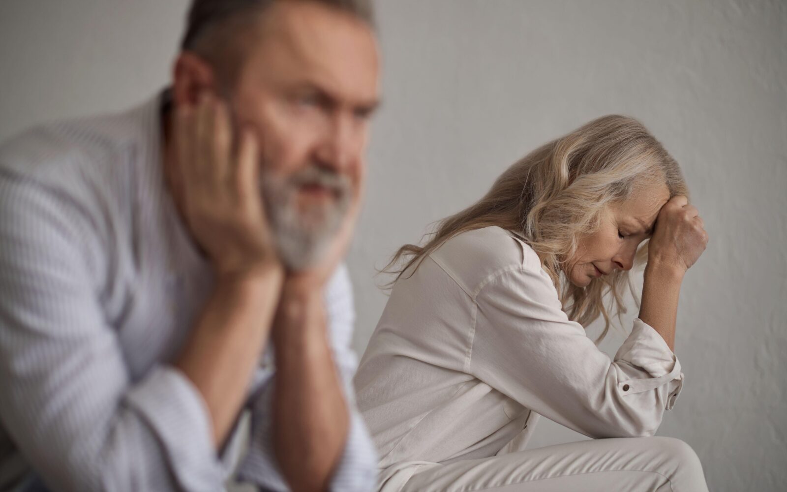 Moški in ženska sedita vsak sebi, zamišljena in žalostna
