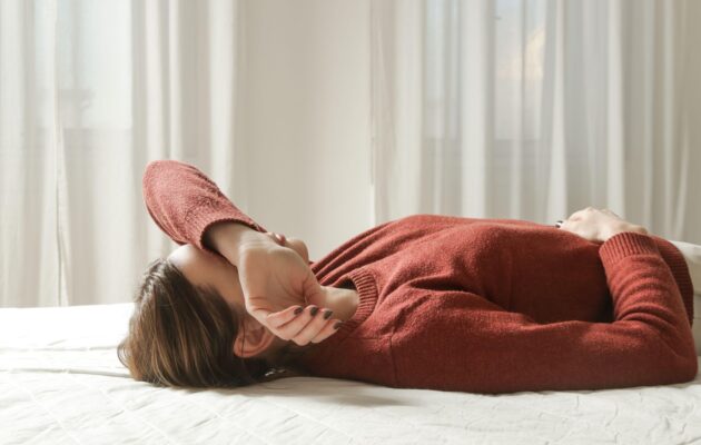 Ženska leži na postelji - perimenopavza - urujenost in menjava razpoloženja