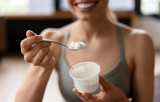 Ženska po vadbi je beljakovinsko bogato malico - jogurt.