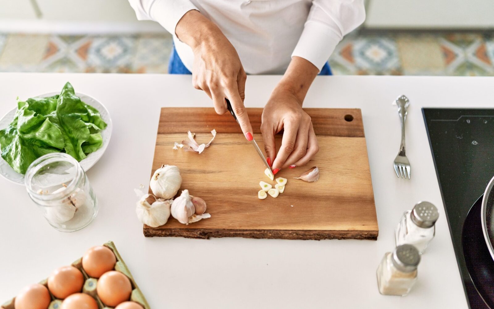 Sveže rezan česen na deski, kjer se ob rezanju tvori alicin
