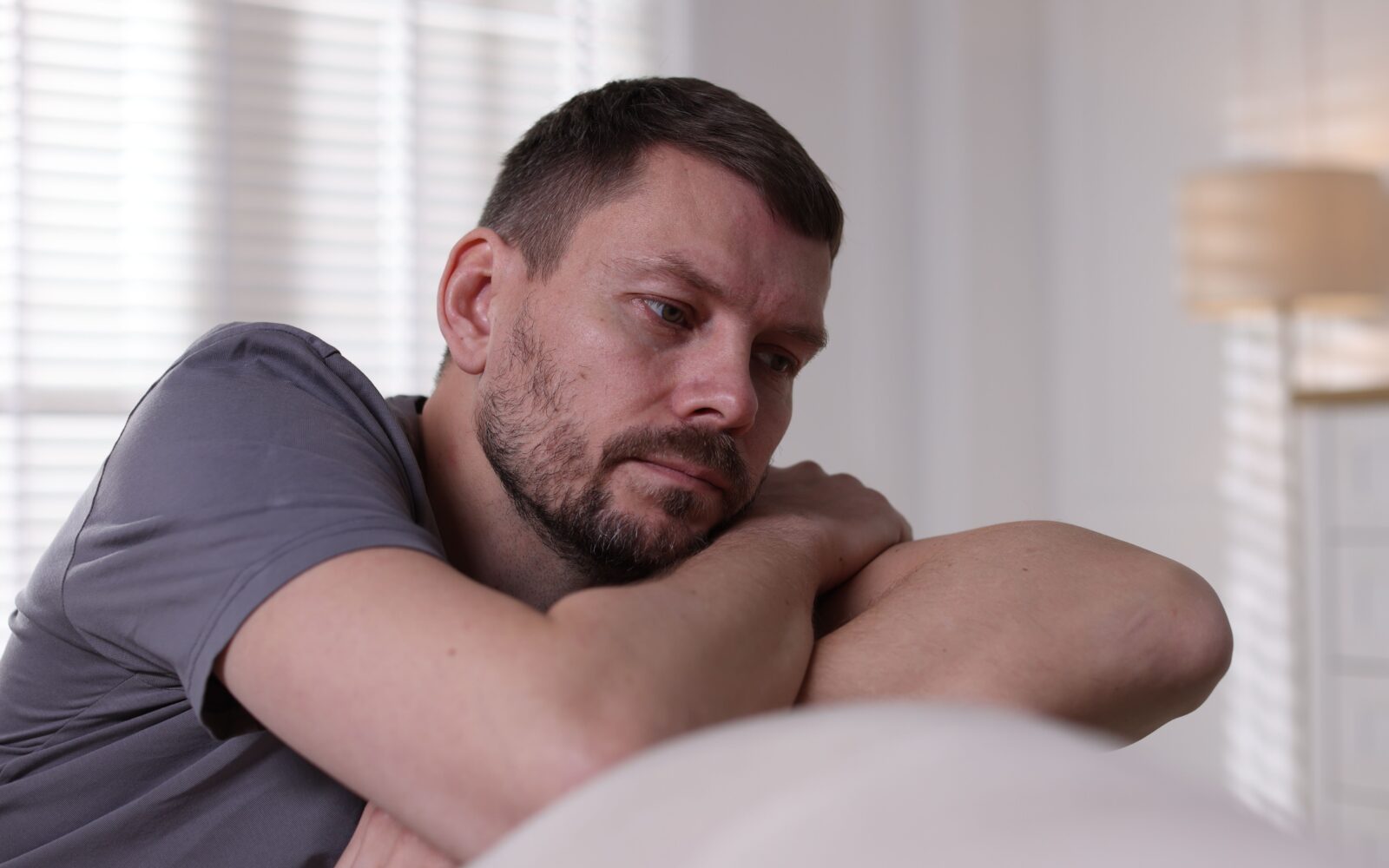 Žalosten, preobremenjen moški na kavču - mikronavade lahko pozitivno vplivajo na naše mentalno zdravje