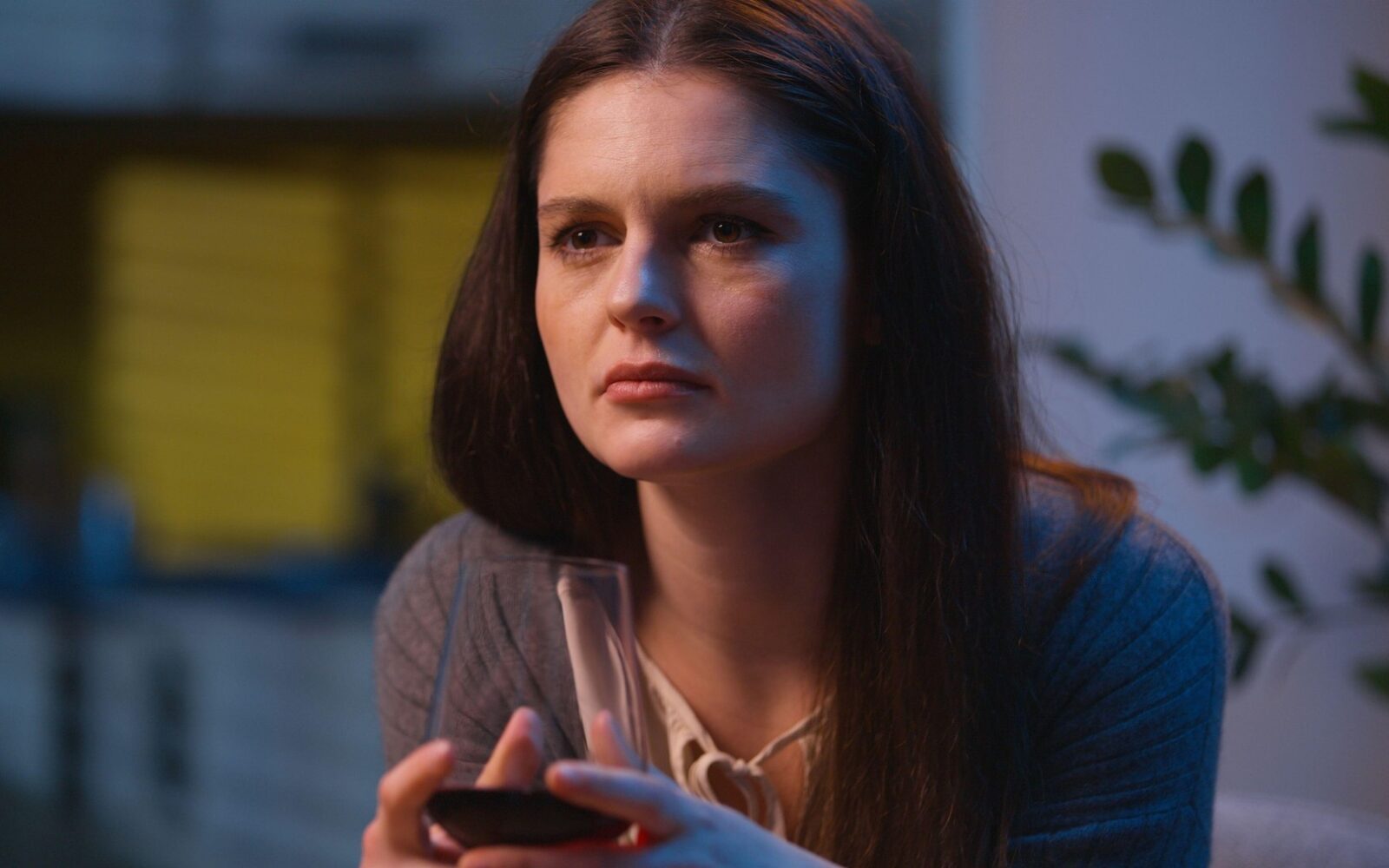 Ženska s kozarcem vina v roki skuša umiriti stres in napetost.