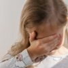 Deklica si zakriva obraz, ker doživlja doživlja strah zaradi zasvojenosti starša