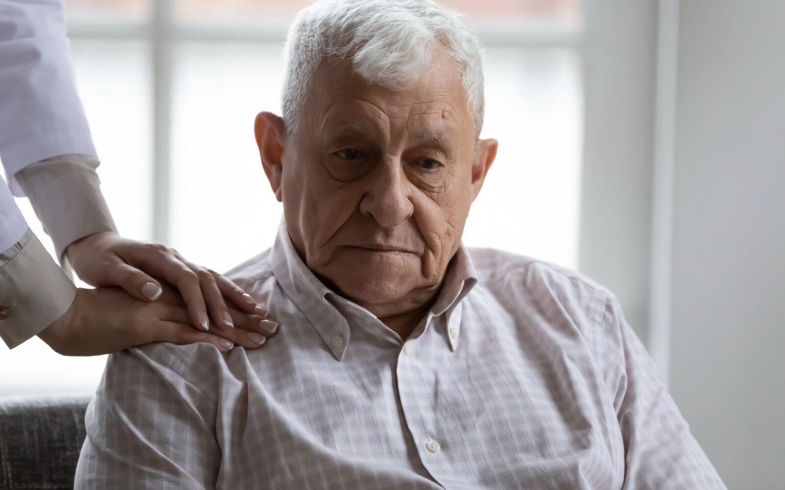 Medicinska sestra miri starejšega moškega pacienta z demenco